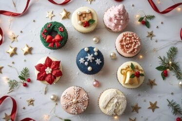 Glam Christmas cupcakes decorated with elegant buttercream designs, wreaths, poinsettias, snowflakes, and festive holiday details