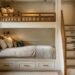 Beautifully designed built-in bunk bed room with wood millwork, built-in stairs with drawers, and individual reading lights
